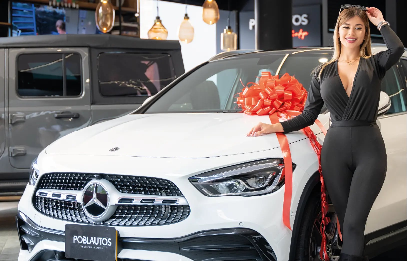 Modelo de Models 1A junto a Mercedes-Benz con moño rojo