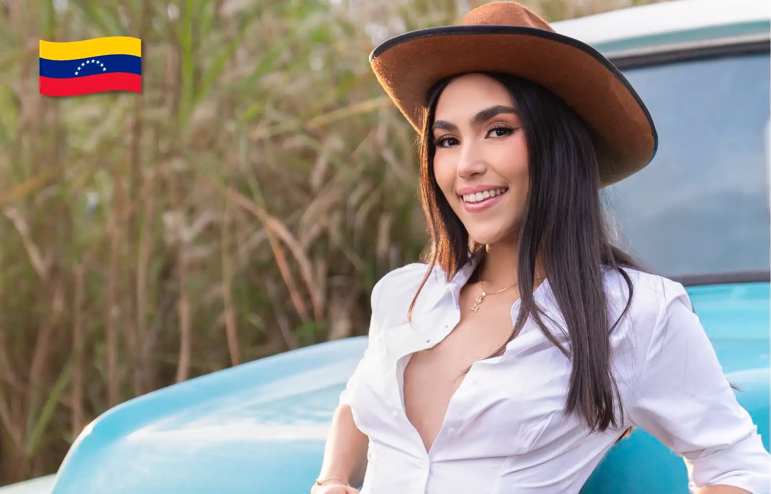 Modelo de Models 1A de Venezuela sonriendo con sombrero y camisa blanca en exterior