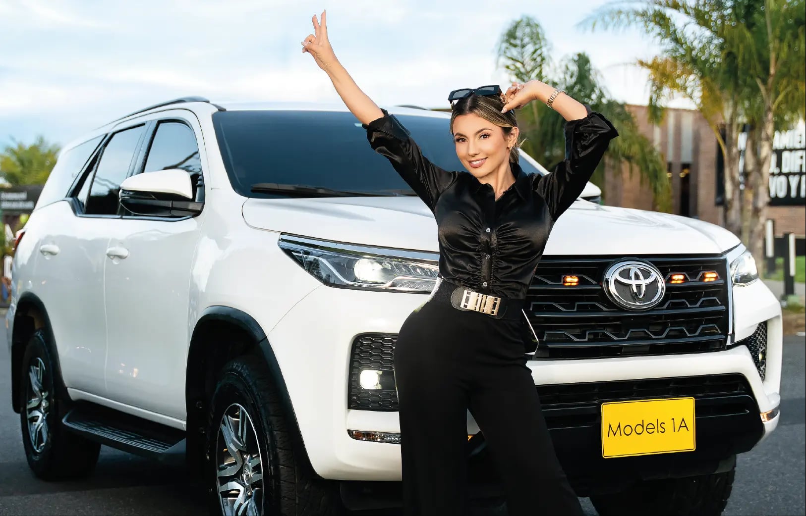 Modelo profesional de Models 1A posando frente a camioneta Toyota blanca