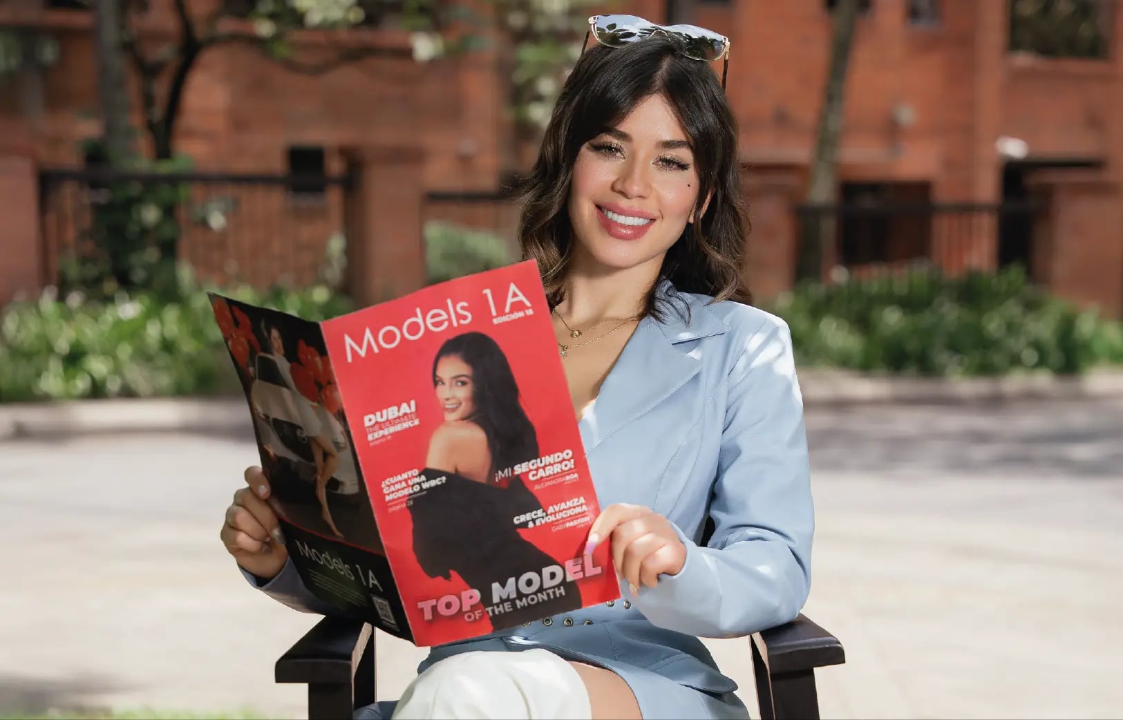 Modelo profesional de Models 1A leyendo revista de la agencia al aire libre